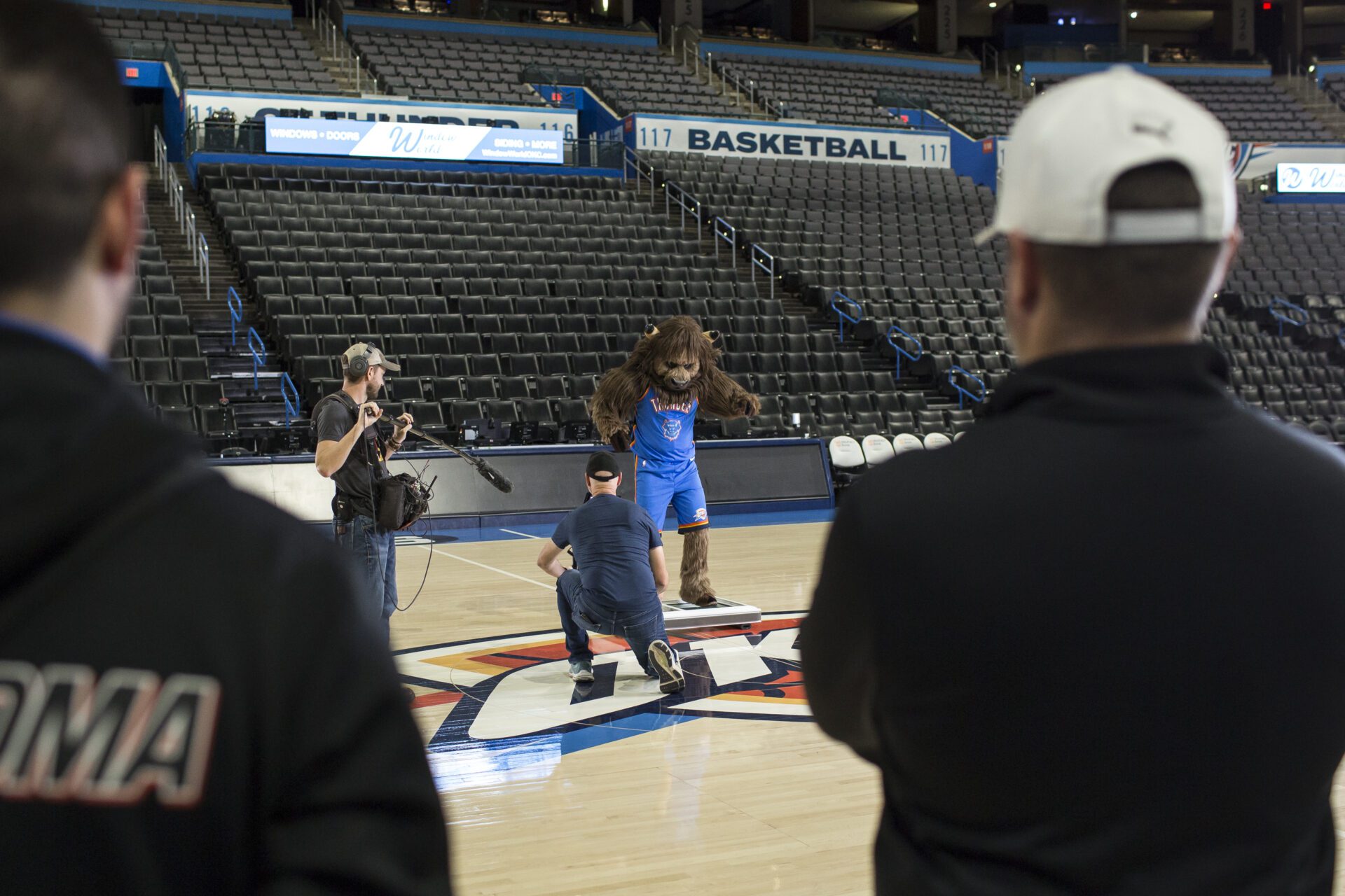 mascot in empty gym being filmed